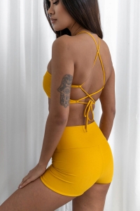bodya żółta góra stroju kąpielowego na modelce – wiązana na plecach, widok z tyłu